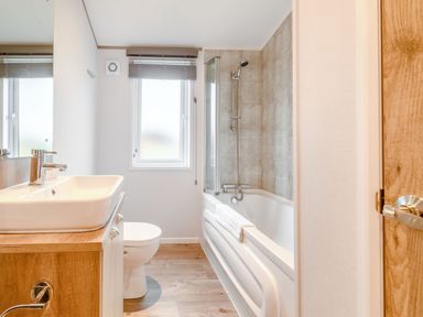 A bathroom featuring a sink, toilet, and bathtub at Oak Waterside Spa in Carlton Miniott near Thirsk