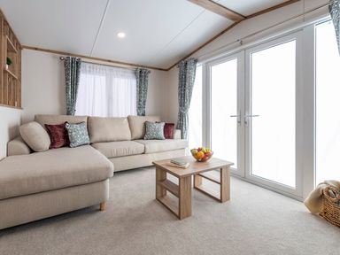 A living room with a sofa and coffee table at Redwood Waterside Spa Carlton Miniott near Thirsk