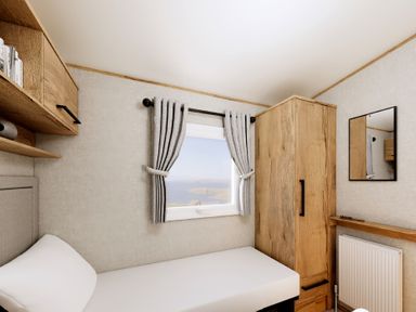 A bedroom with a bed and wardrobe at Willow Waterside Spa Carlton Miniott near Thirsk