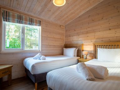 A bedroom with two single beds and a window at Fir Tree Waterside Spa in Carlton Miniott near Thirsk