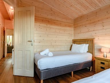 A bedroom with a bed and a bedside table at Fir Tree Waterside Spa Carlton Miniott near Thirsk