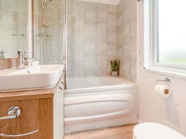 A bathroom with a bath tub, sink, shower and toilet at Spindle Spa in Carlton Miniott near Thirsk