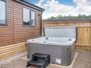 A hot tub with steps beside a wooden fence at Spindle Spa (Pet) Carlton Miniott near Thirsk