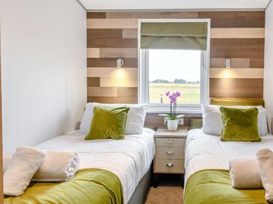 A bedroom with two beds and a window at Spindle Spa (Pet) Carlton Miniott near Thirsk