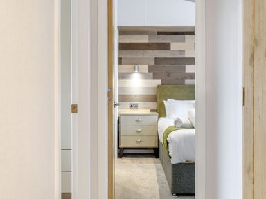 A bedroom with a bed and nightstand at Oak Waterside Spa (Pet) Carlton Miniott near Thirsk