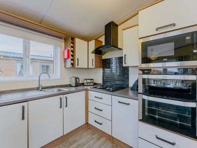 A kitchen with a stove and oven at Larch Waterside Spa Carlton Miniott near Thirsk