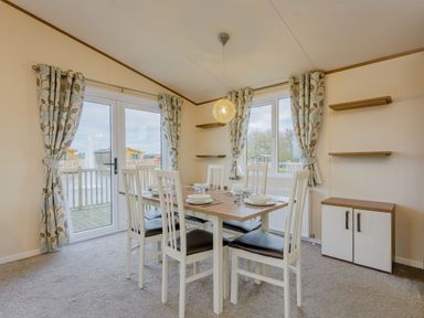 A dining room with a table and chairs at Larch Waterside Spa Carlton Miniott near Thirsk