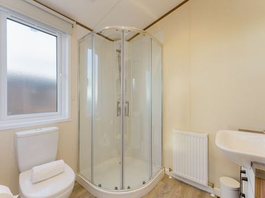 A bathroom with a shower, toilet, and sink at Larch Waterside Spa Carlton Miniott near Thirsk