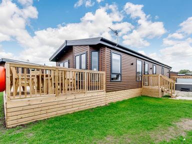 A cabin with decking and steps at Beech Waterside Spa Carlton Miniott near Thirsk