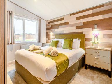 A bedroom with a bed and bedside table at Beech Waterside Spa Carlton Miniott near Thirsk