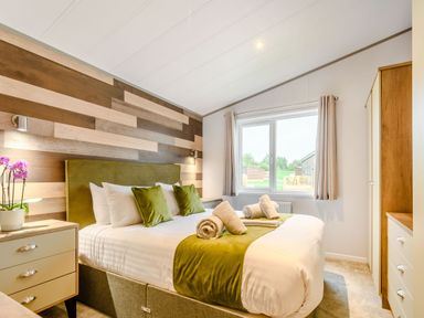 A bedroom with a bed and wardrobe at Beech Waterside Spa (Pet) Carlton Miniott near Thirsk