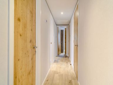 A hallway with wooden doors and wooden flooring at Beech Waterside Spa (Pet) Carlton Miniott near Thirsk