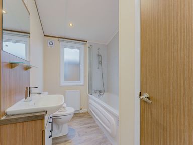 A bathroom with a sink, toilet, and bathtub at Larch Waterside Spa (Pet) Carlton Miniott near Thirsk
