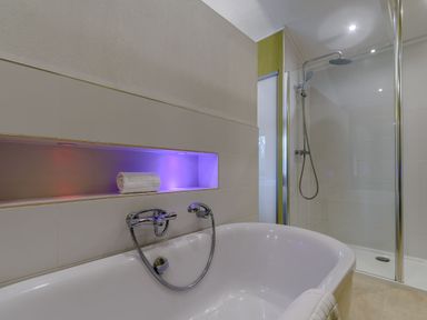 A bathroom with a bathtub and shower area at Cherry Tree in Carlton Miniott near Thirsk