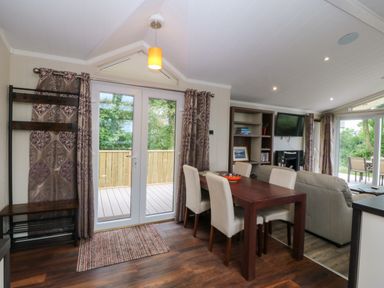 A dining area with table and chairs at Plas Marchog Lodge in Rhoscefnhir near Pentraeth