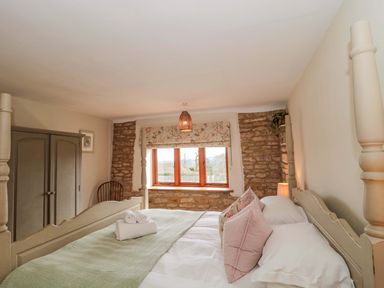 A bedroom with a bed and wardrobe at Daisy Bank near Stow-On-The-Wold