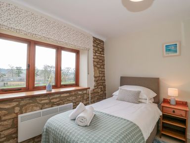 A bedroom with a bed and windows at Daisy Bank Maugersbury near Stow-On-The-Wold