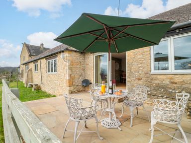 An outdoor patio with a table and chairs at Daisy Bank Maugersbury near Stow-On-The-Wold