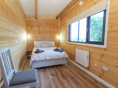 A bedroom with a bed and a chair at Killinure Cottage in Glasson, County Westmeath