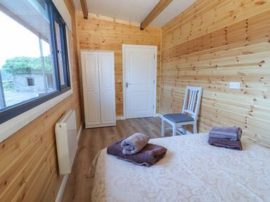 A bedroom with a bed and a chair at Killinure Cottage, Glasson, County Westmeath
