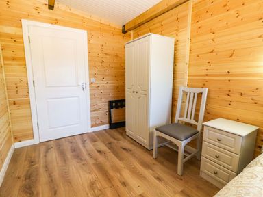 A bedroom with a wardrobe and nightstand at Killinure Cottage Glasson, County Westmeath