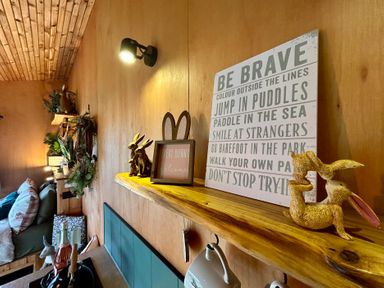 A living room with a shelf displaying rabbits and wall art at Harriet in Llangurig
