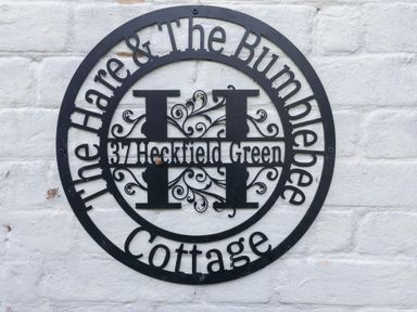 A sign displaying the name and address at The Hare & the Bumblebee Cottage in 37 Heckfield Green