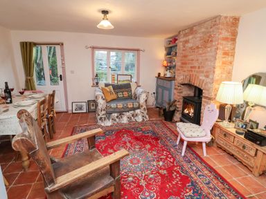 A living room with a couch and fireplace at The Hare & the Bumblebee Cottage
