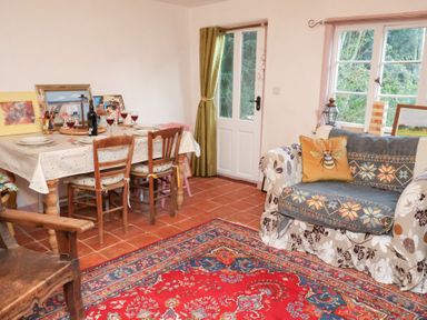 A dining room with a table and chairs at The Hare & the Bumblebee Cottage