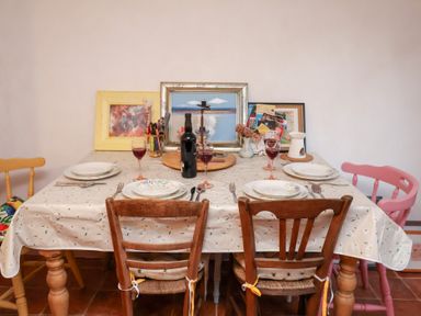 A dining room table set with plates and glasses at The Hare & the Bumblebee Cottage