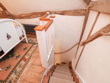 A staircase in a bedroom at The Hare & the Bumblebee Cottage