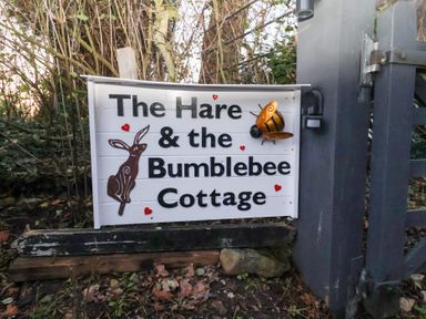 A sign with a rabbit and bee at The Hare & the Bumblebee Cottage
