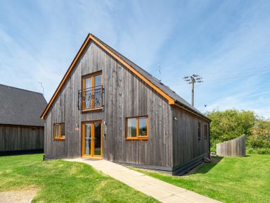 A house with wooden exterior and balcony at Aspen Lodge Near Brigg