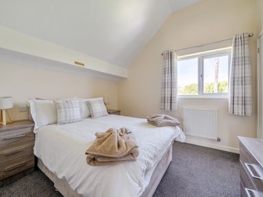 A bedroom with a bed and window at Aspen Lodge near Brigg
