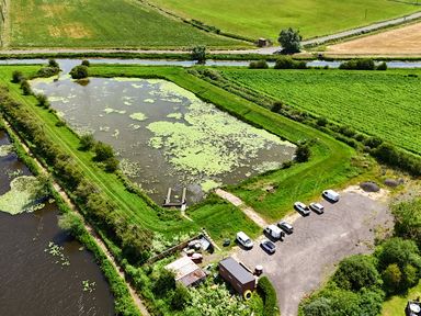 An aerial view of a pond with vehicles parked nearby at Aspen Lodge Near Brigg