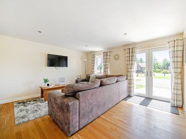 A living room with a sofa and television at Sage Lodge near Brigg