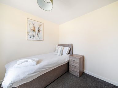 A bedroom with a single bed and bedside table at Sage Lodge near Brigg