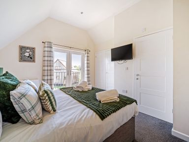 A bedroom with a bed and television at Sage Lodge near Brigg