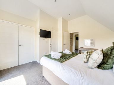 A bedroom with a bed and television at Sage Lodge Near Brigg