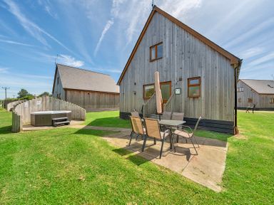 A house with a patio and hot tub in the outdoor area at Sage Lodge near Brigg