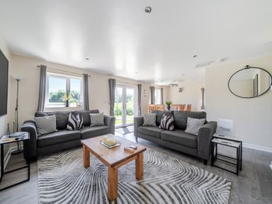 A living room with sofas and a dining area at Raven Lodge Near Brigg