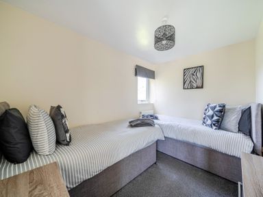 A bedroom with two beds and a window at Raven Lodge near Brigg