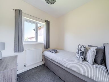 A bedroom with a bed and window at Raven Lodge Near Brigg