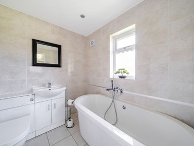A bathroom with a bathtub, sink, and toilet at Raven Lodge near Brigg