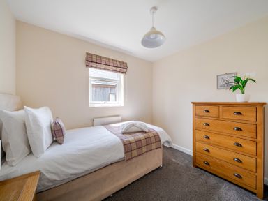 A bedroom with a single bed and dresser at Paddington Lodge near Brigg