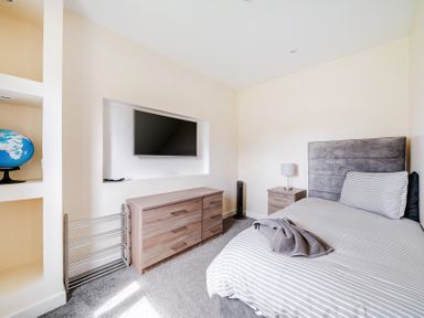 A bedroom with a bed and television at Charcoal Lodge in Brigg