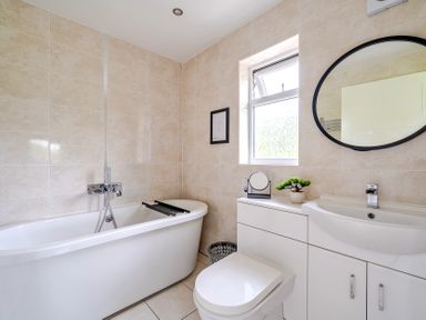 A bathroom with a bathtub, toilet, and sink at Charcoal Lodge Brigg