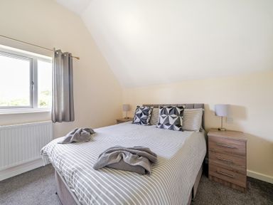 A bedroom with a bed and bedside tables at Charcoal Lodge in Brigg