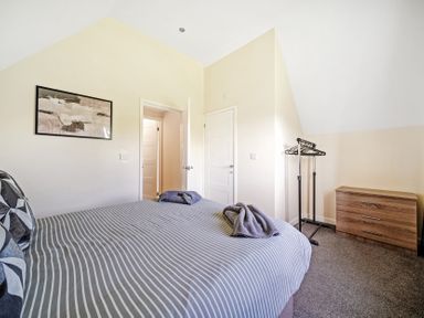 A bedroom with a bed and clothes rack at Charcoal Lodge in Brigg