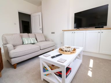 A living room with a sofa and a television at The Old Bank Flat in North Tawton